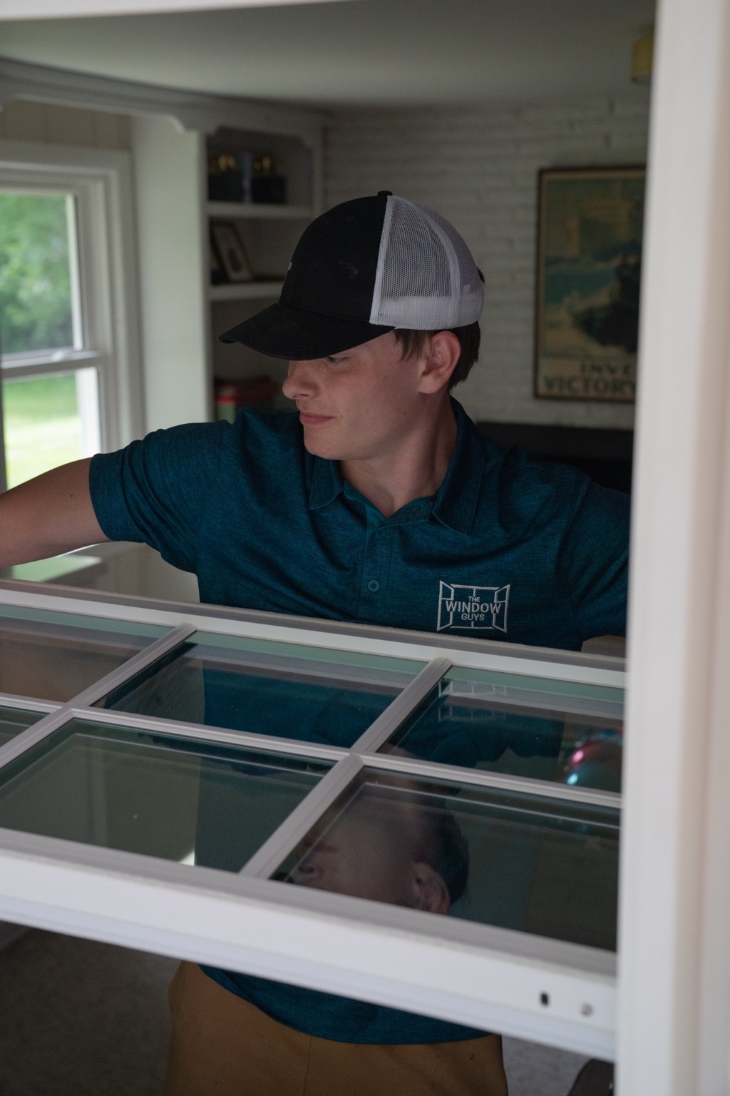Installer carrying a newly assembled window wearing The Window Guys gear
